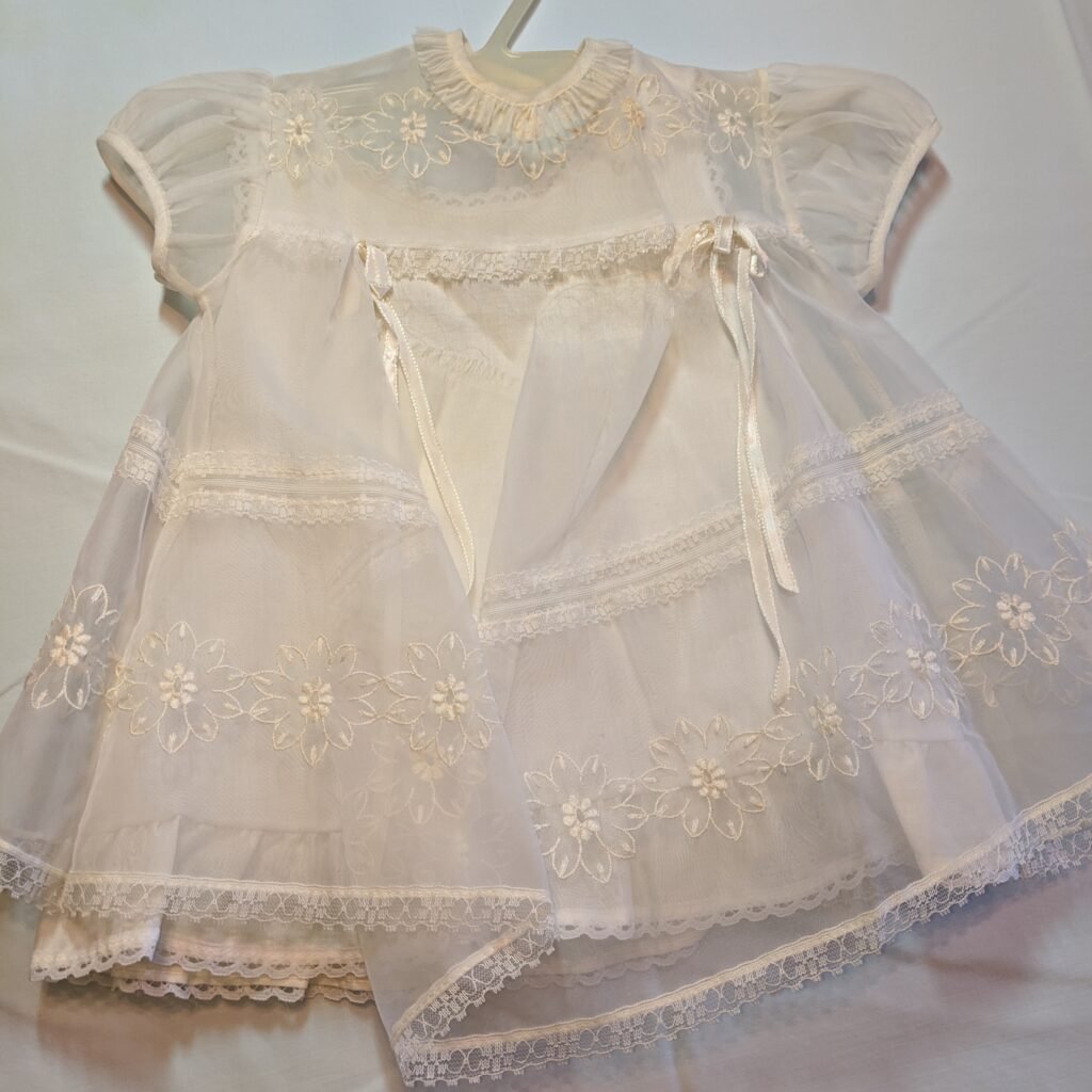 before image of vintage christening gown showing frayed seam and stains